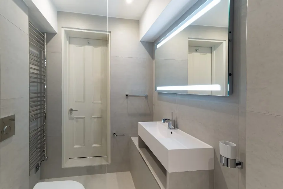 Contemporary bathroom with a backlit mirror