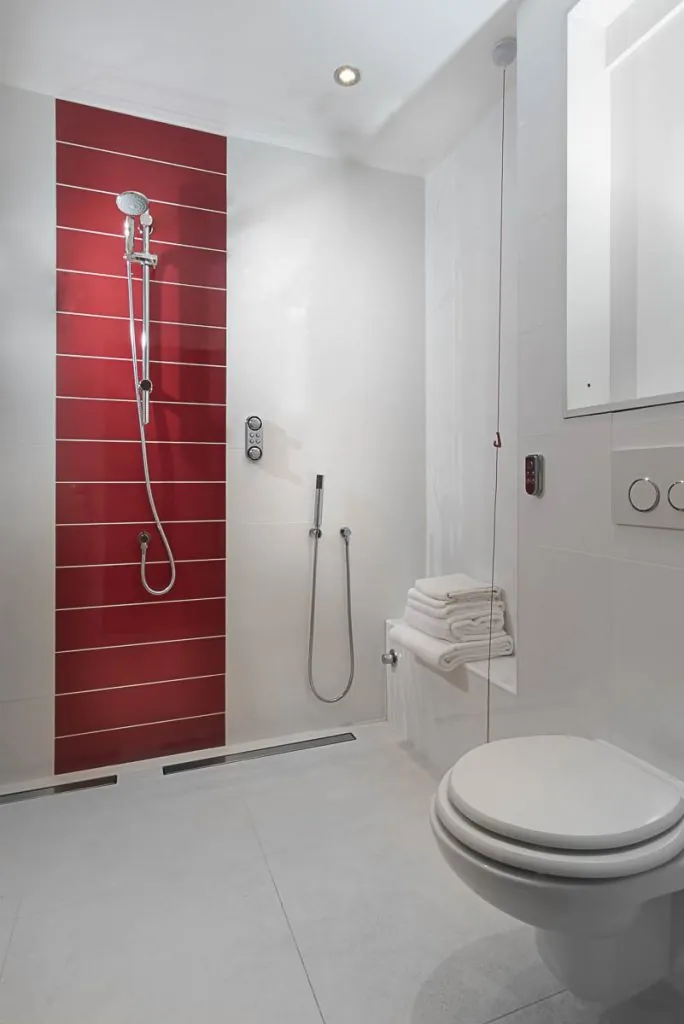 Level-access wet room with a red accent wall