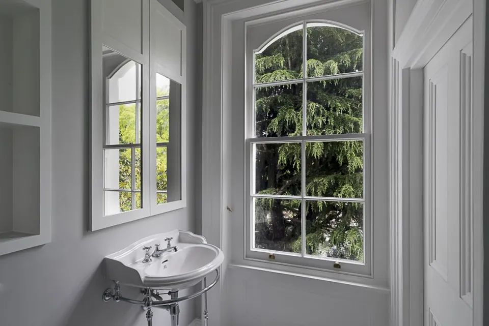 Classic bathroom with a pedestal basin by an arched window