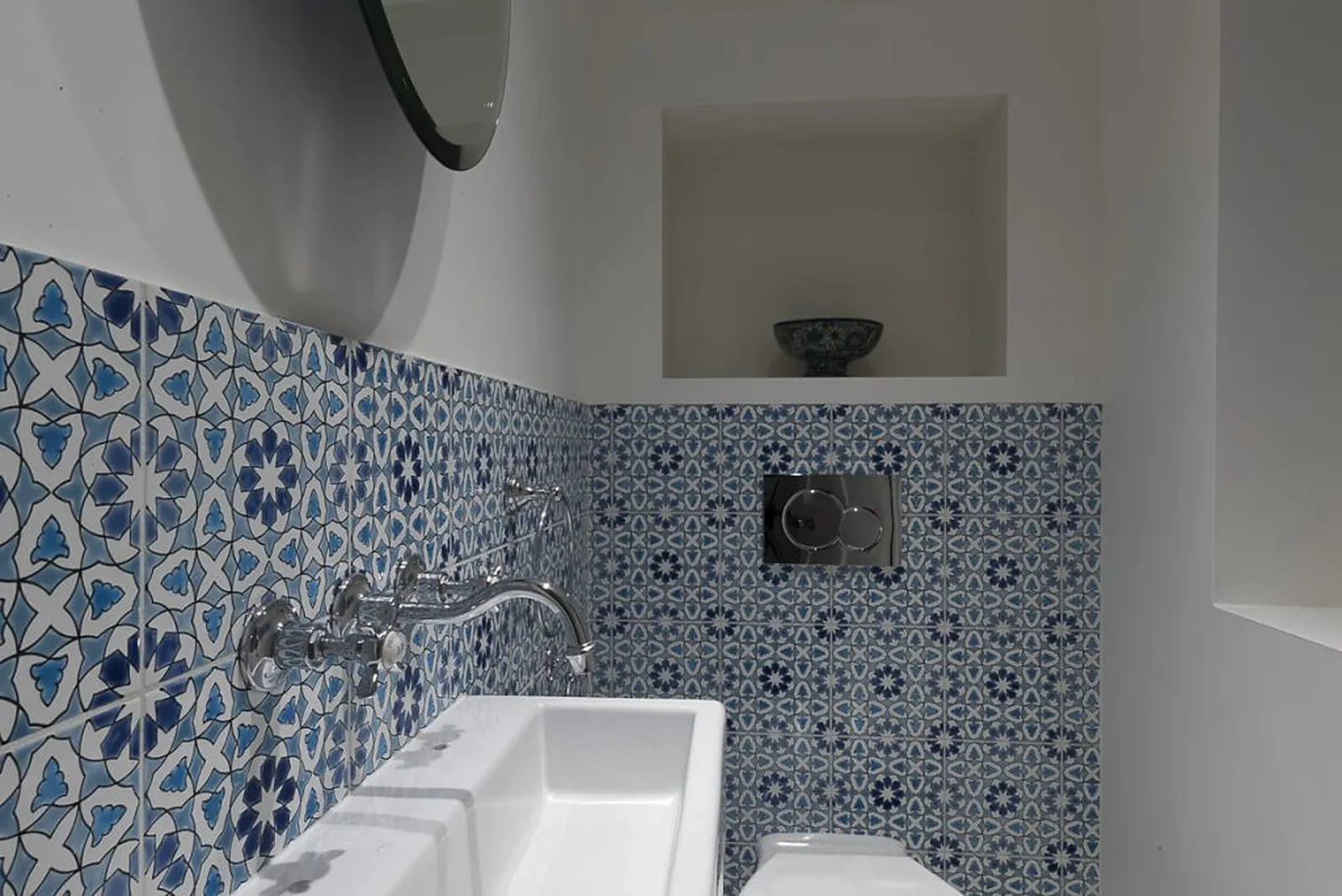 Blue and white patterned tiles behind a wall-hung basin and WC