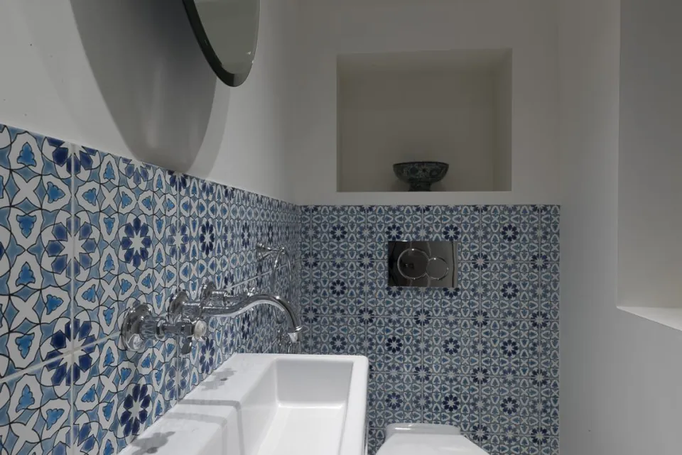 Patterned blue and white tiles with a wall-hung basin