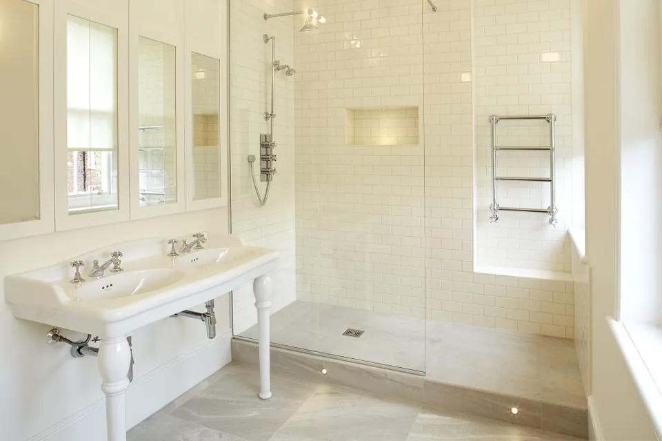 Bright bathroom with a double washstand and walk-in shower