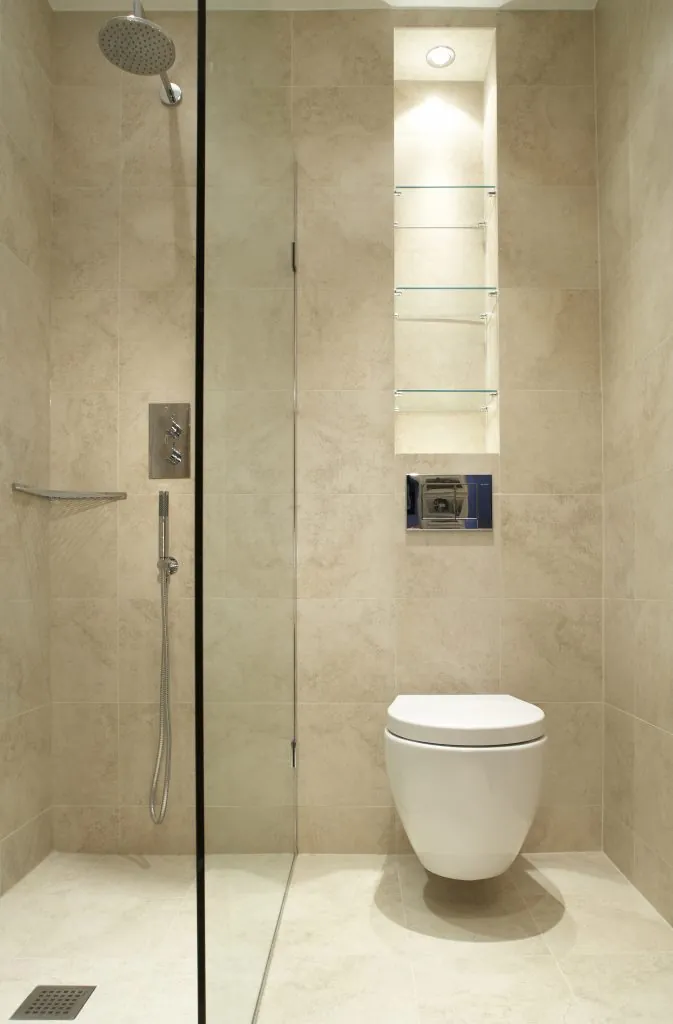 Narrow stone-tiled wet room with a walk-in shower