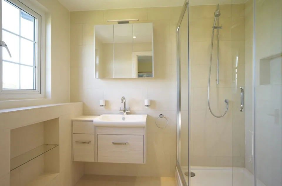 Cream bathroom with a mirrored cabinet and glass shower