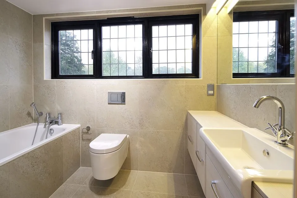 Warm stone bathroom with leaded windows